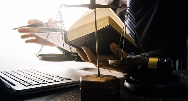 Abogado penalista ejerciendo con un libro de penal, una balanza de justicia y un mazo