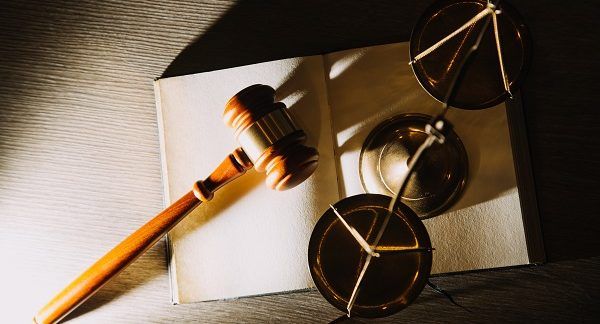 Imagen de un mazo de juez, balanza de la justicia y un libro, todo representando el derecho penal