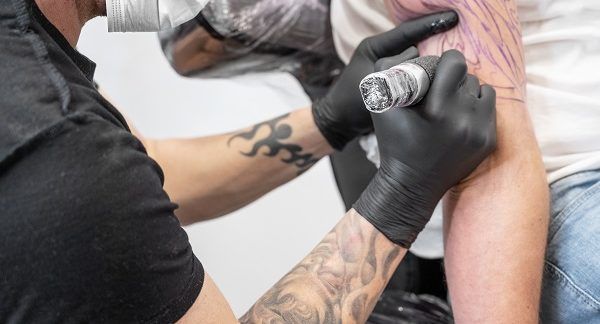 Tatuador realista realizando un tatuaje