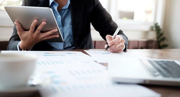 Hombre en una mesa con muchos papeles realizando servicios de gestoría administrativa