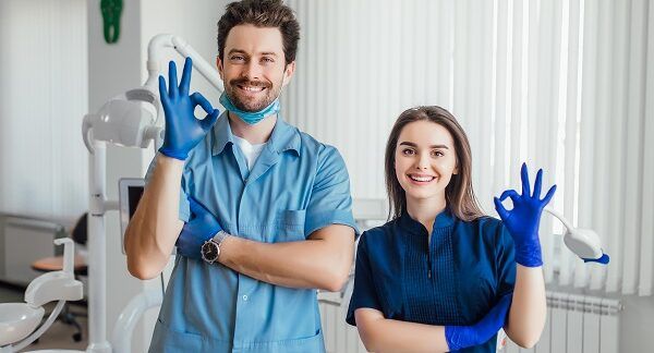 Dos dentistas saludando con la mano en una clínica dental de Sevilla
